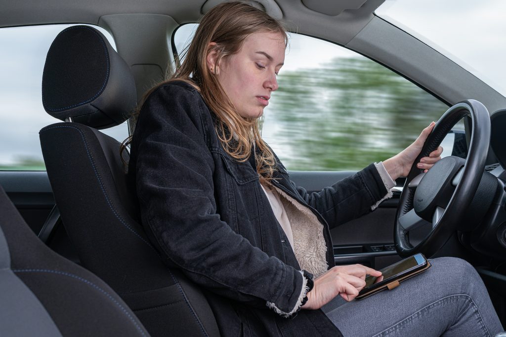 Woman Is texting On A Mobile While Driving A Car